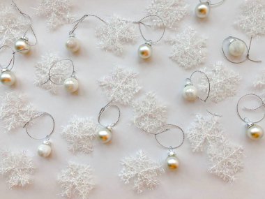 Beyaz arka planda kar taneleri ve gümüş Noel topları yakın plan görüntüsü. Boşluğu kopyala