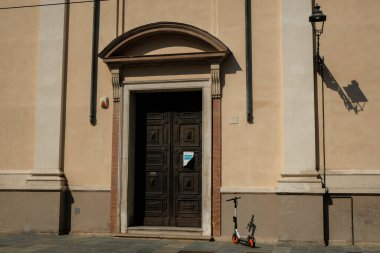Eylül 2020 Parma, İtalya: Elektrikli scooter güneşli bir günde mobil uygulama ile antik bina boyunca kiralanmaya hazır. Yeşil ulaşım kavramı