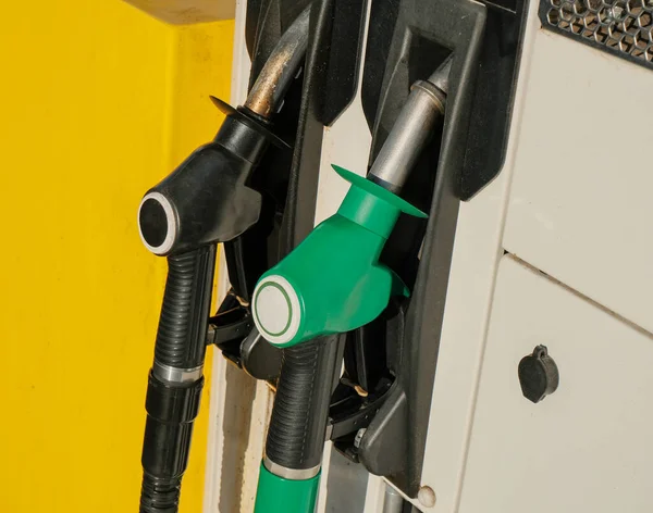 Two green and black gas pump nozzles at gas station close-up. Gas industry. Energy. Gas/diesel, benzine, petroleum station business.