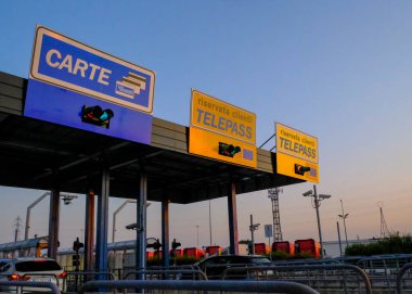 Eylül 2020 Parma, İtalya: İtalyan otobanındaki Telepass gişelerinden geçen arabalar. Otoyol engeli ödeme çizgileri.