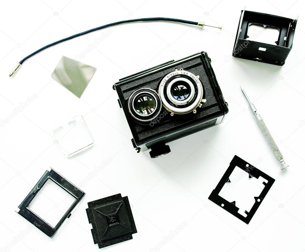Old TLR camera, disassembled into parts, isolated.