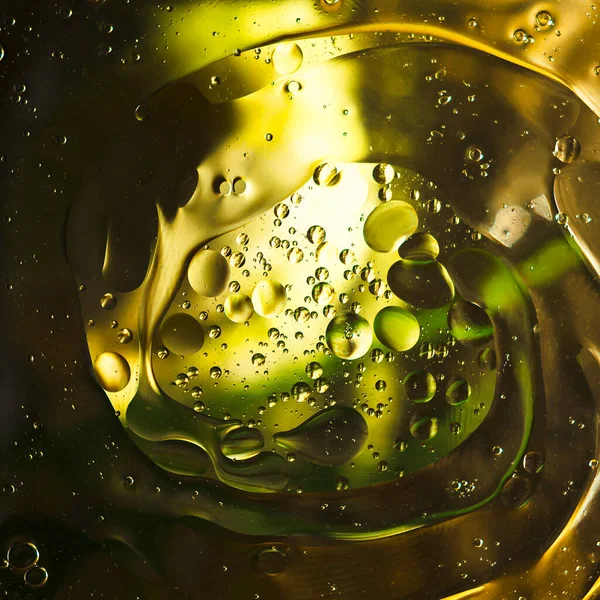Abstração em tons amarelos e escuros e movimento circular de bolhas . — Fotografia de Stock