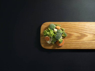 bir kesme tahtası üzerinde dondurulmuş sebzeler