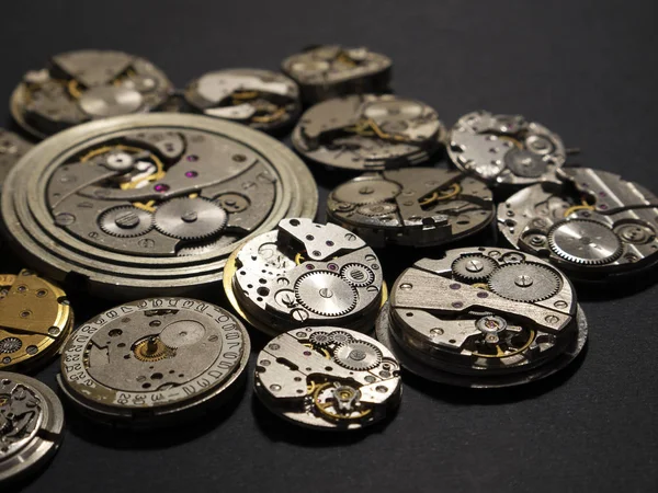 Mechanisms of watches and their parts on a black background