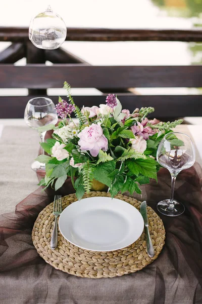 Apparecchiare la tavola per una cena romantica. Bellissimi fiori in un vaso sul tavolo — Foto Stock