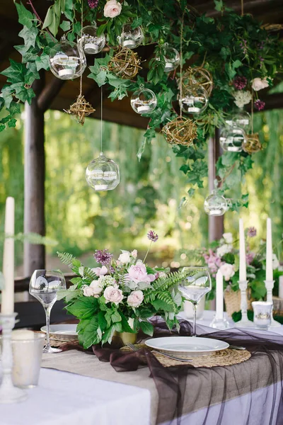 Mesa para una cena romántica. Hermosas flores en un jarrón sobre la mesa — Foto de Stock