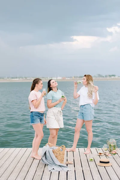 Τρία Κορίτσια Στέκονται Μια Ξύλινη Προβλήτα Μπροστά Στο Νερό Ανάπαυση — Φωτογραφία Αρχείου
