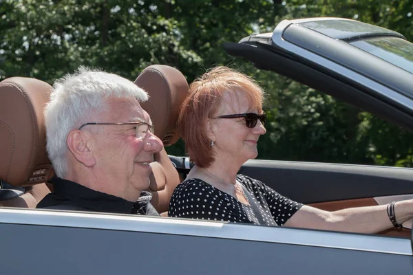 Smiling happy senior couple in the car on a sunny day