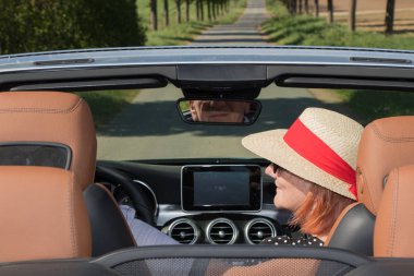 Güneş şapkası ve eşi bir arabada güzel yaşlı kadınla
