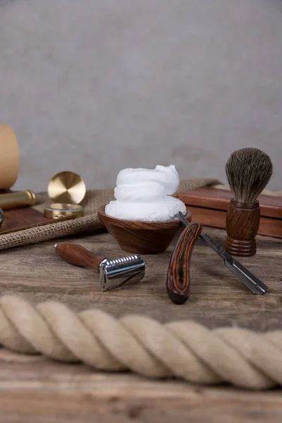 shaving accessories  - wooden razor with shaving brush and shaving foam on a rustic wooden background