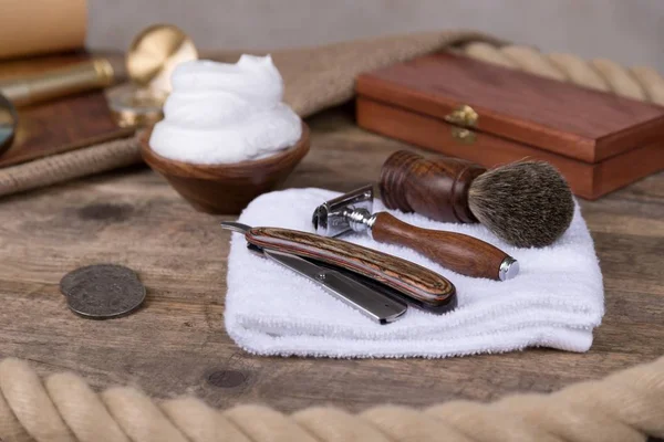 shaving razor with shaving brush and shaving foam on a rustic wooden table - vintage shaving accessories