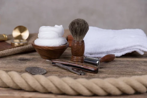 vintage shaving accessories  - wooden razor with shaving brush and shaving foam on a rustic wooden table