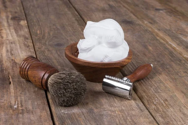 vintage shaving accessories  - wooden razor with shaving brush and shaving foam on a rustic wooden table