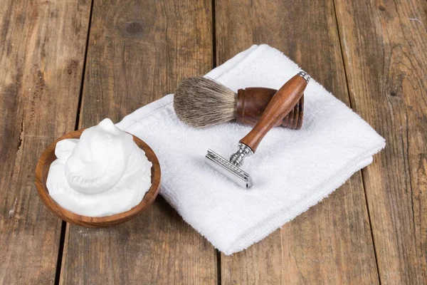 vintage shaving accessories  - wooden razor with shaving brush and shaving foam on a rustic wooden table