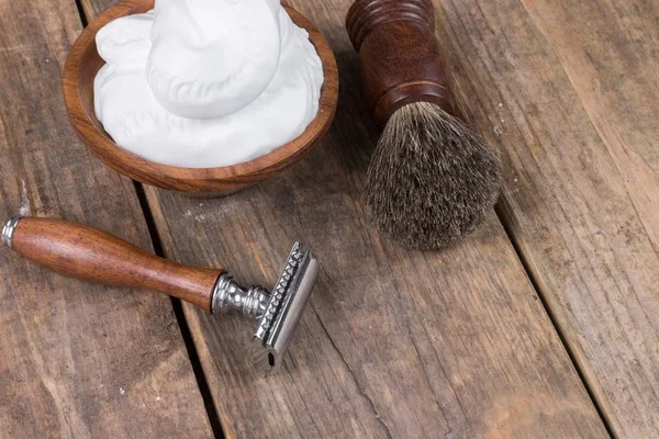 vintage shaving accessories  - wooden razor with shaving brush and shaving foam on a rustic wooden table