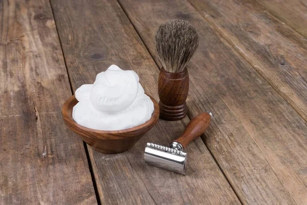 vintage shaving accessories  - wooden razor with shaving brush and shaving foam on a rustic wooden table