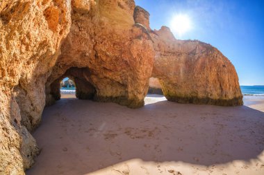 Famous beach rock oluşumunda Algarve, Portekiz mağaralar. İki mağaralar sonra okyanusa görebilirsiniz, rock güneş parlıyor.