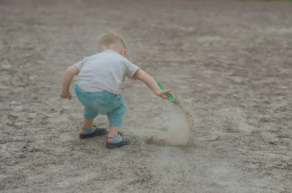 Schattige kleine jongen speelt met een speeltje op de speelplaats — Stockfoto