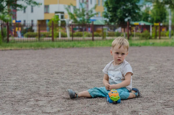 Mignon petit garçon joue avec un jouet sur l'aire de jeux — Photo