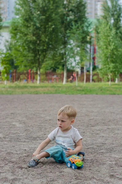 Carino bambino gioca con un giocattolo sul parco giochi — Foto Stock