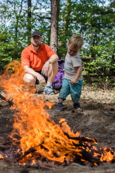 Vader en zoon maken een grote brand in het bos — Stockfoto