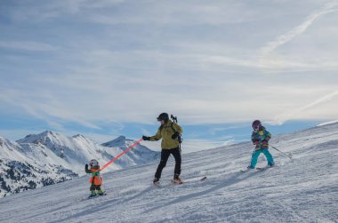 Obertauern Kayak merkezinde dağlar ve kayakçılar ailesinin çarpıcı görünümü