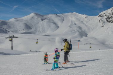 Obertauern Kayak merkezinde dağlar ve kayakçılar ailesinin çarpıcı görünümü