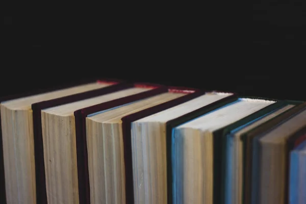 Eski açık ders kitabıyla kütüphanede kitap, okuma masasında edebiyat metin arşivi yığını ve akademik eğitim öğrenme kavramı için okul çalışma odası arka planındaki kitaplıklar.