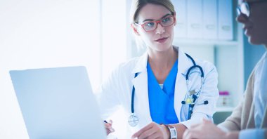 Masada oturan gülümseyen güzel genç bayan doktor..
