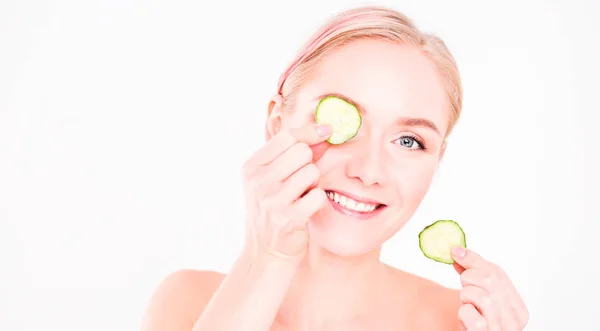 Mooie jongedame met plakjes komkommer op witte achtergrond — Stockfoto