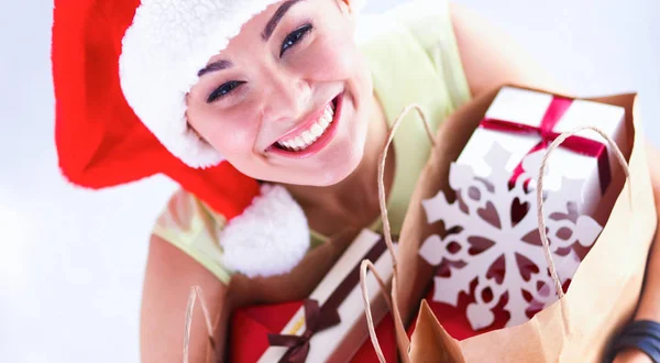 Menina feliz no chapéu de santa segurando um saco de compras com caixa de presente — Fotografia de Stock