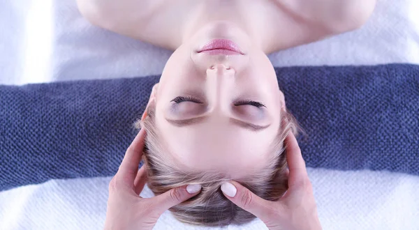 Mujer joven acostada en una mesa de masaje, relajándose con los ojos cerrados. Una mujer. Salón de spa —  Fotos de Stock