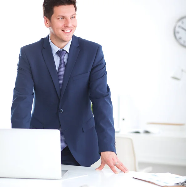 Vertrouwen succesvolle jonge zakenman leunend wapens op zijn Bureau — Stockfoto