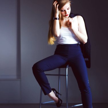 Genç kadın bir sandalyede oturuyor. Genç kadın