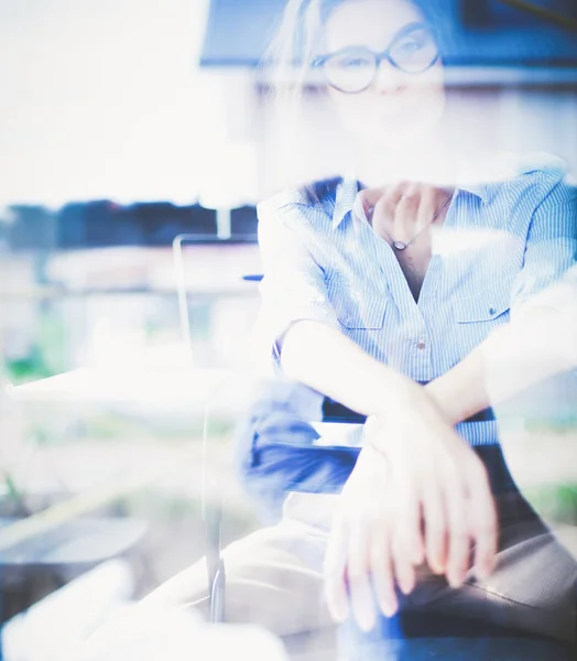 Young woman sitting at office table with laptop,view through window. Young woman — Stock Photo, Image