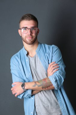 Mutlu bir casual adam ayakta karanlık bir arka plan üzerinde izole portresi. Yakışıklı erkek poz.