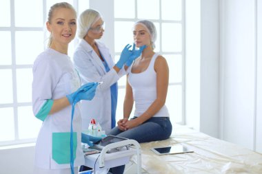 Güzel kadın elinde şırıngayla doktorun yanında duruyor..