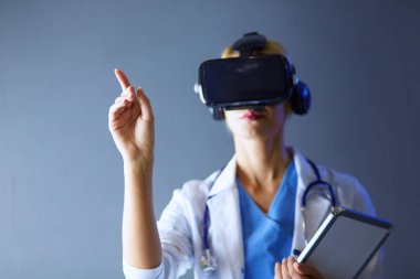 Sanal gerçeklik gözlüğü takan kadın doktor beyaz arka planda izole edilmiş..