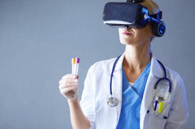 Sanal gerçeklik gözlüğü takan kadın doktor beyaz arka planda izole edilmiş..