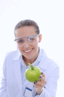 Diş hekimi kadın elinde yeşil elma ve diş fırçası tutuyor. Dişçi doktorlar. Kadın doktorlar