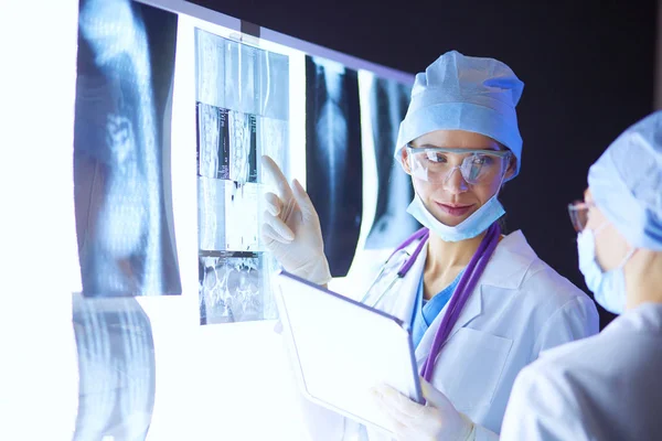 Two female women medical doctors looking at x-rays in a hospital. — Stock Photo, Image