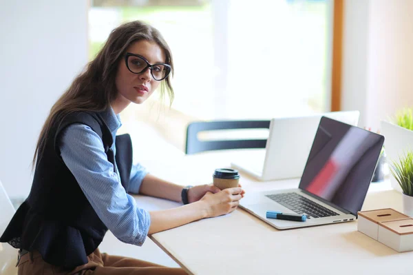 Młoda kobieta siedząca przy stole z laptopem. Młoda kobieta. Laptop — Zdjęcie stockowe