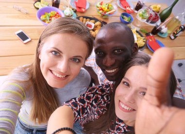 Öğle yemeği sırasında selfie çeken bir grup insan. Kendim. Arkadaşız. Arkadaşlar yemek yerken fotoğraflanır.