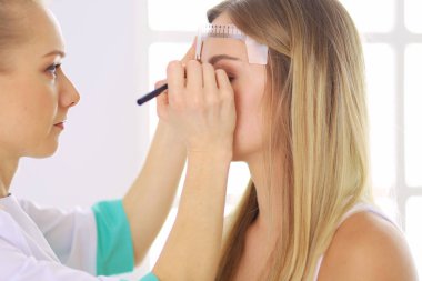 Kaşlar için kalıcı makyaj. Güzellik salonunda kalın kaşlı güzel bir kadın..