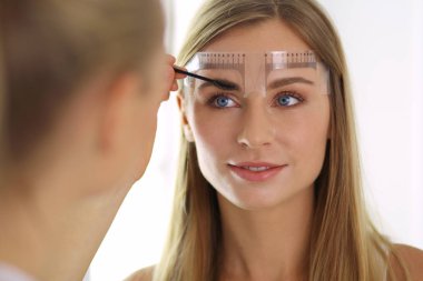 Kaşlar için kalıcı makyaj. Güzellik salonunda kalın kaşlı güzel bir kadın..