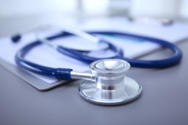 Tıbbi ekipman: Beyaz arka planda mavi steteskop ve tablet. Tıbbi ekipman