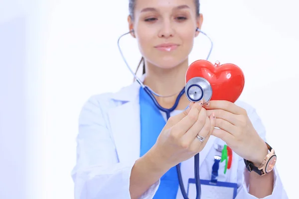肯定的な女医が分離した聴診器と赤のハートマークと立っています。女性医師 — ストック写真