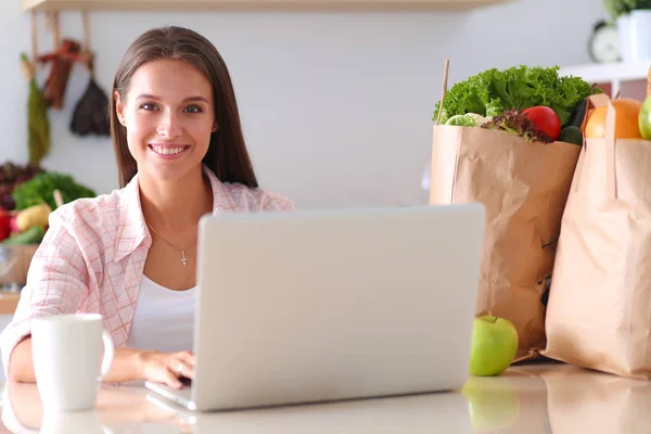 Smiling woman online shopping using tablet and credit card in kitchen . Smiling woman — Stock Photo, Image