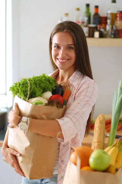 Egy fiatal nő zöldséges bevásárlószatyrot tart a kezében. Fiatal nő — Stock Fotó