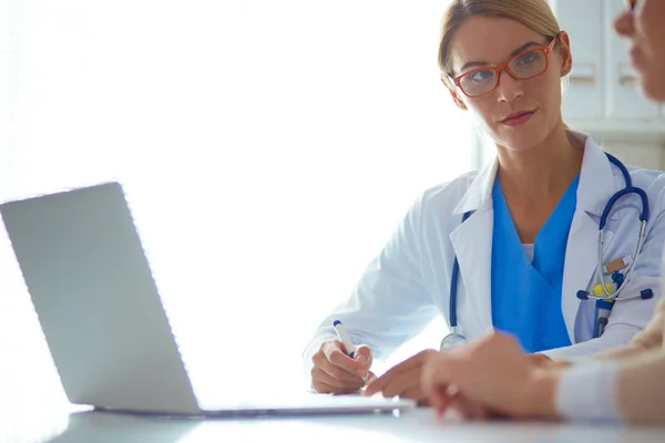 Doctor y pareja de pacientes están discutiendo algo, sentados en el escritorio. —  Fotos de Stock